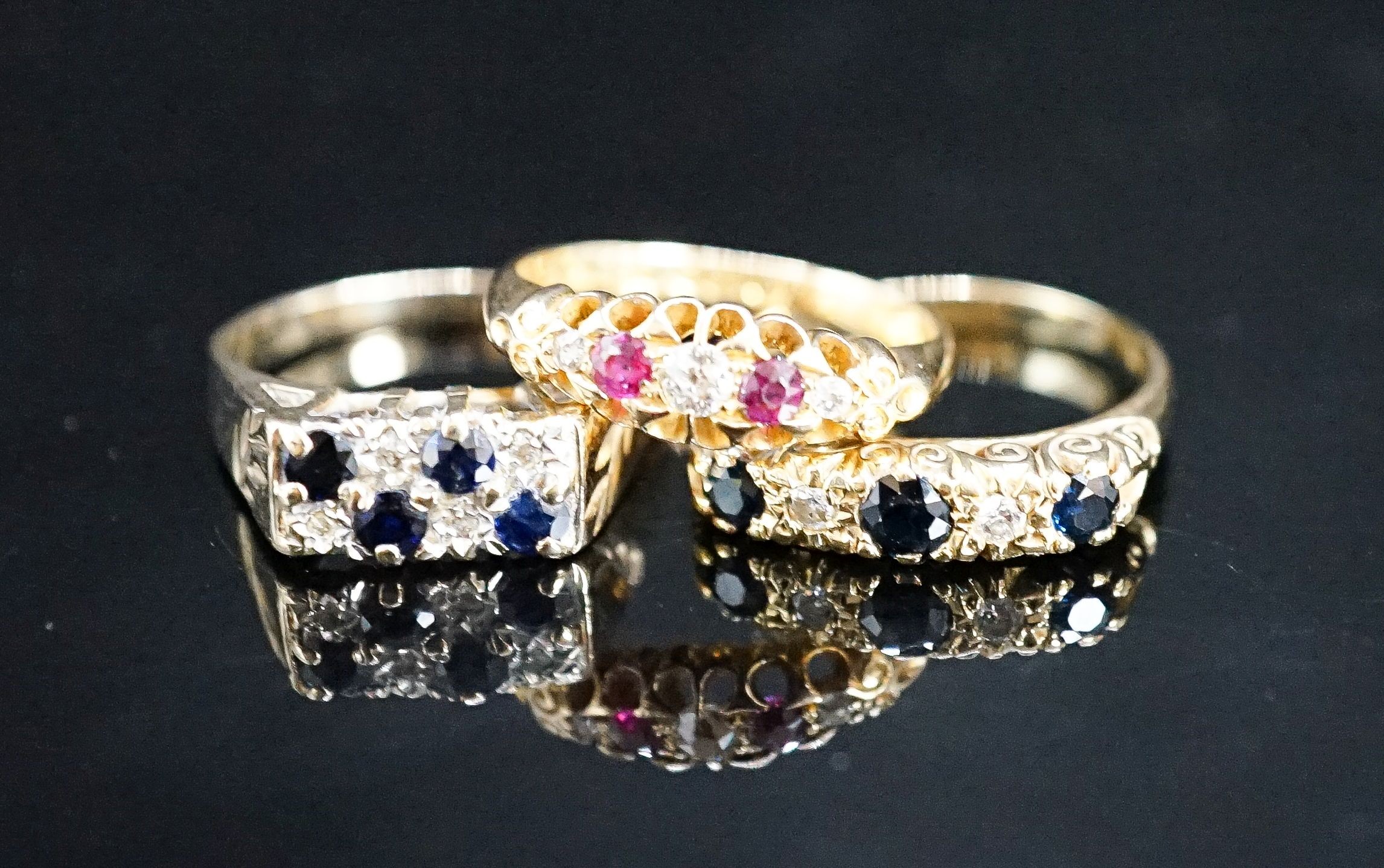 A George V 18ct gold, ruby and diamond chip five stone ring, a later similar sapphire and diamond ring gross 6.7 grams and a 9ct gem set ring, gross 4 grams.